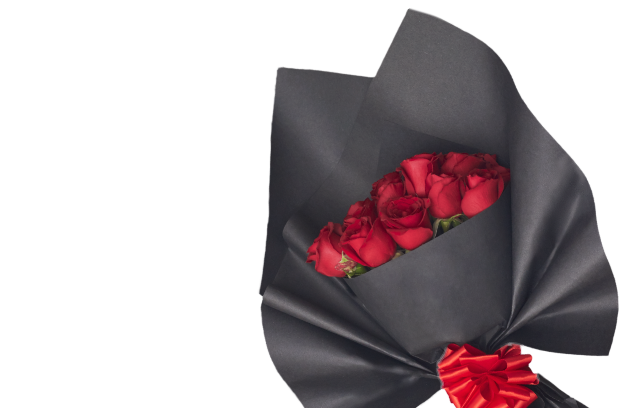 Ramo de rosas rojas envuelto en papel negro con un moño rojo.