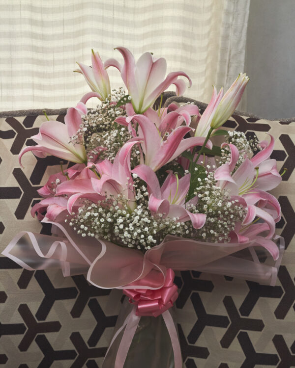 ramo_de_acapulcos_1 Ramo de lirios orientales acapulco rosas con gypsophila, envuelto en papel coreano rosado transparente y decorado con moño rosado, arreglo floral elegante visto de frente.