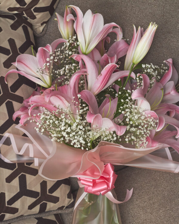 ramo_de_acapulcos_2 Vista superior de ramo con lirios orientales acapulco rosas y gypsophila, envuelto en papel coreano rosado transparente con moño rosado.