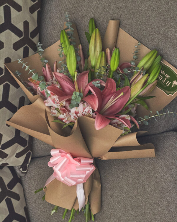 ramo_de_lirios_rosas_astromelias_minidolar_3 Vista superior de ramo con lirios rosas, astromelias y mini dólar, envuelto en papel kraft con estructura redonda.