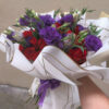 ramo_de_rosas_y_lisianthus_2 Persona sosteniendo ramo buchón de rosas rojas y lisianthus morados envuelto en papel coreano blanco, arreglo floral voluminoso listo para entregar.