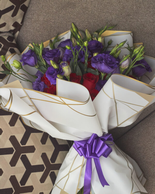ramo_de_rosas_y_lisianthus_3 Vista superior de ramo buchón con rosas rojas y lisianthus morados, envuelto en papel coreano blanco con diseño elegante.