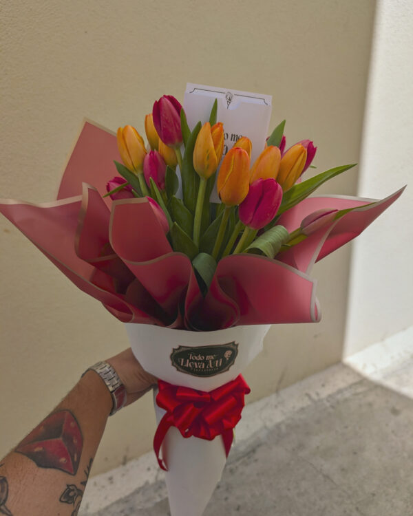 ramo_de_doble_tulipanes_3 Persona sosteniendo ramo de tulipanes anaranjados y rojos, envuelto con papel coreano rojo y blanco, decorado con moño rojo, arreglo floral vibrante y elegante.