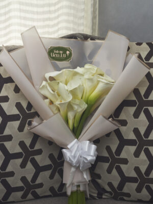 Vista frontal de bouquet de alcatraces con tendencia de envoltura coreana suave.